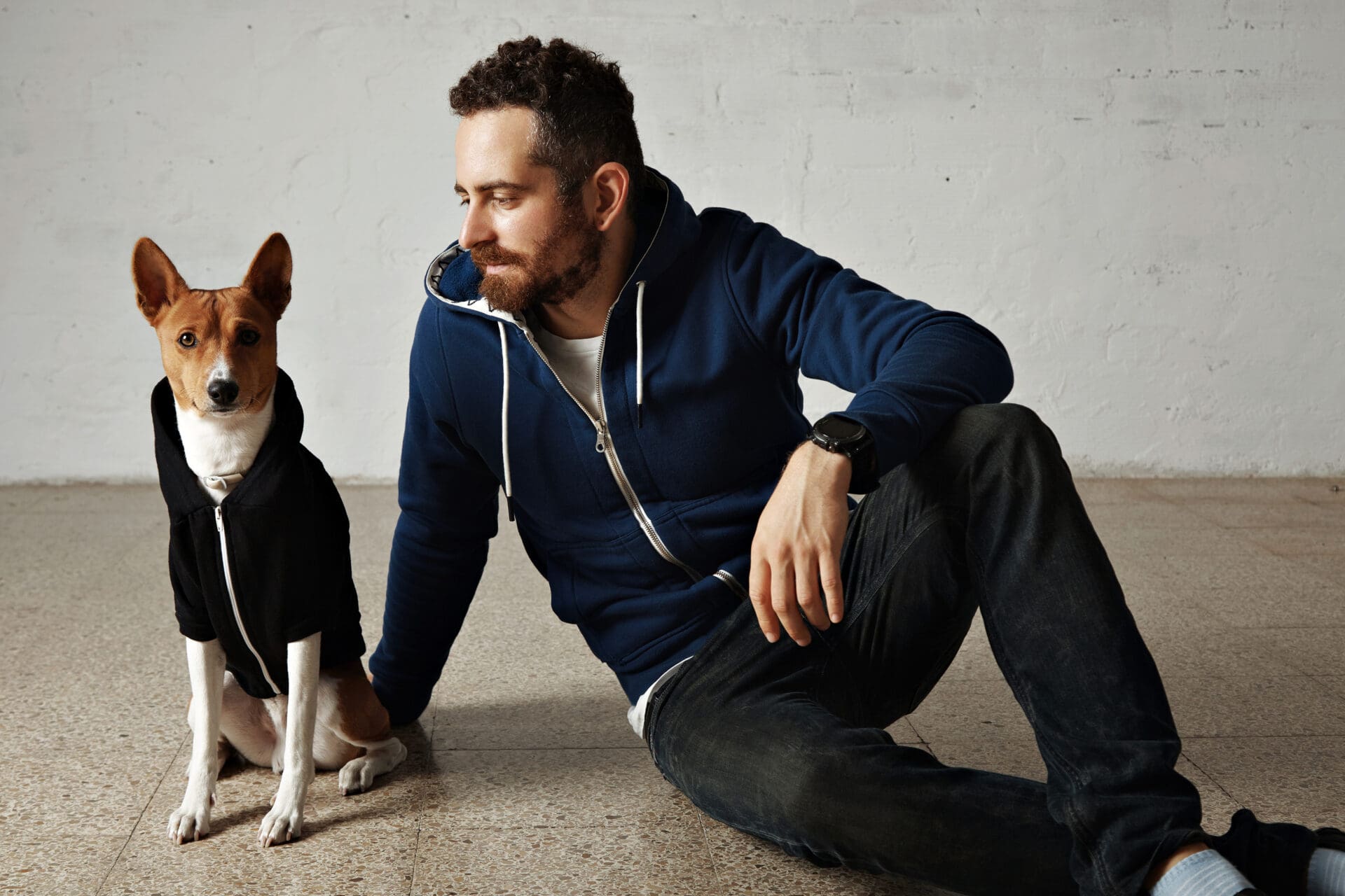 A man sitting on the ground with his dog.